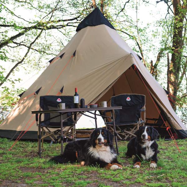 Tipi bell tent with chairs, table and a pair of dogs in front.