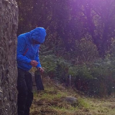 Man in blue jacket being swarmed by midges and insects